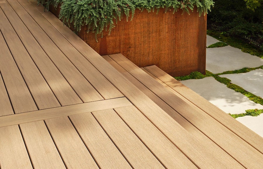 Custom backyard deck designed for outdoor entertaining with comfortable seating and dining area