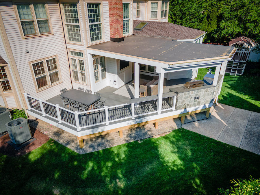 Spacious backyard deck with designated dining and lounge areas for improved traffic flow